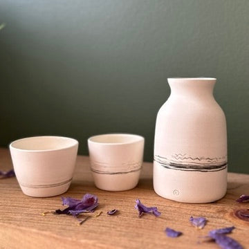 Three ceramic pots on a wooden surface with a dark background